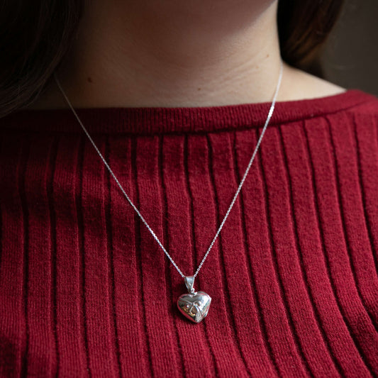 model in red wearing photo locket with bow embellishment