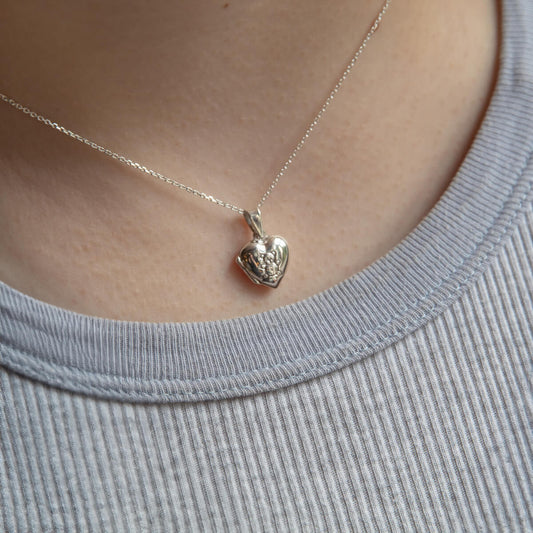 Model wearing tiny kids locket with teddy bear detail