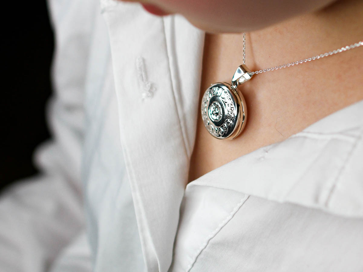 round circle locket necklace on model wearing white shirt