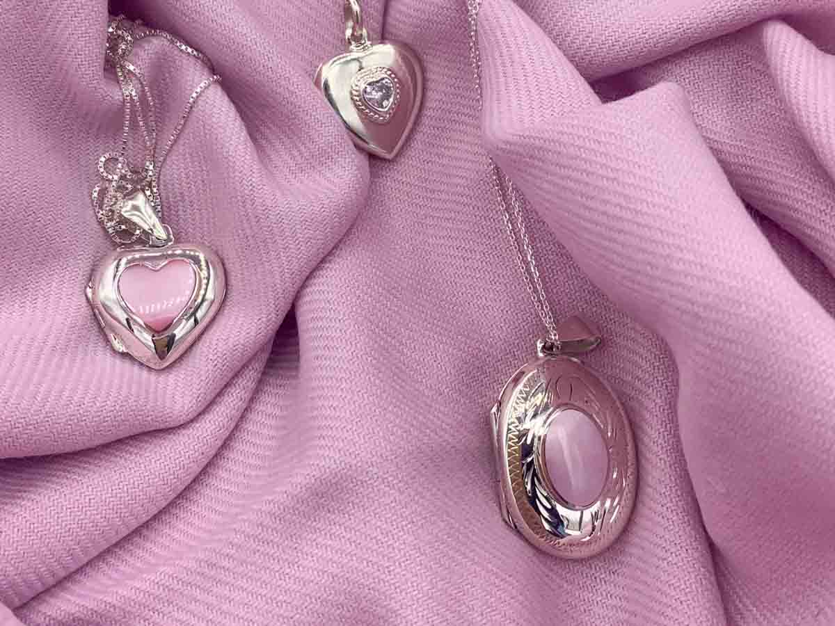 A collection of silver photo locket necklace on a purple background