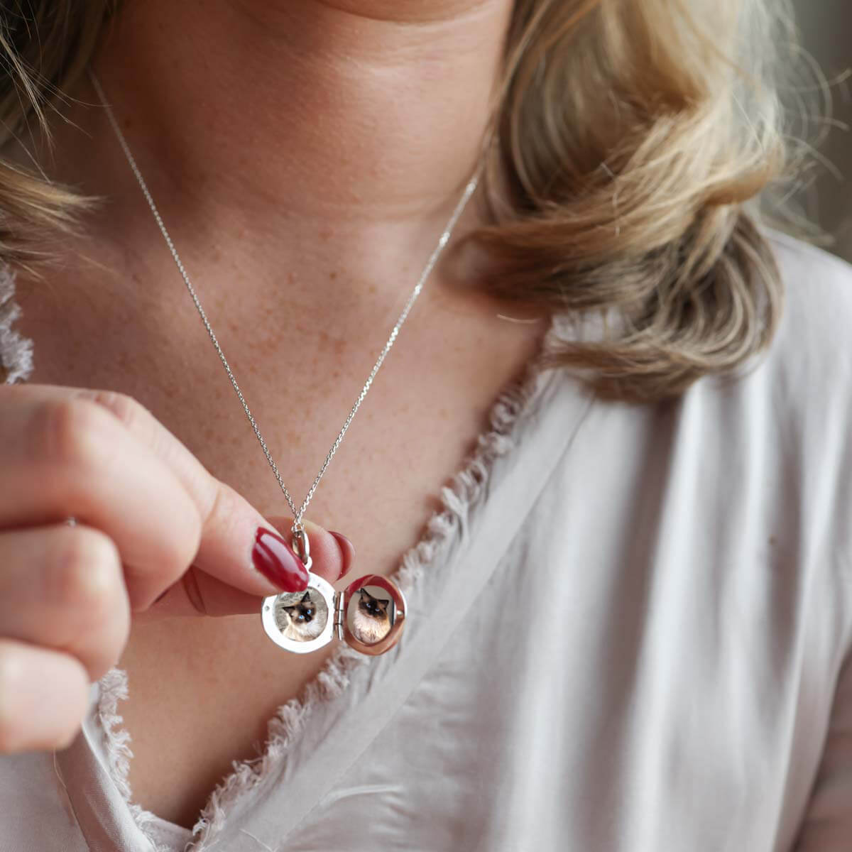 Model wearing grey top showing open locket