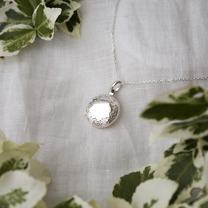 silver locket amidst green foliage