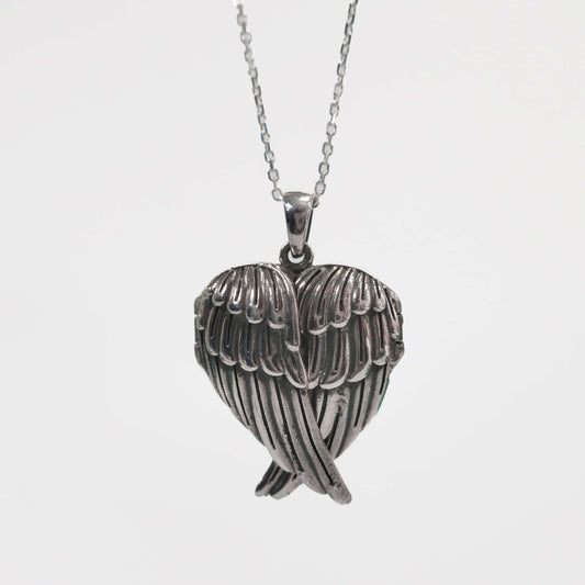 Silver heart-shaped pendant with wings on a chain against a white background