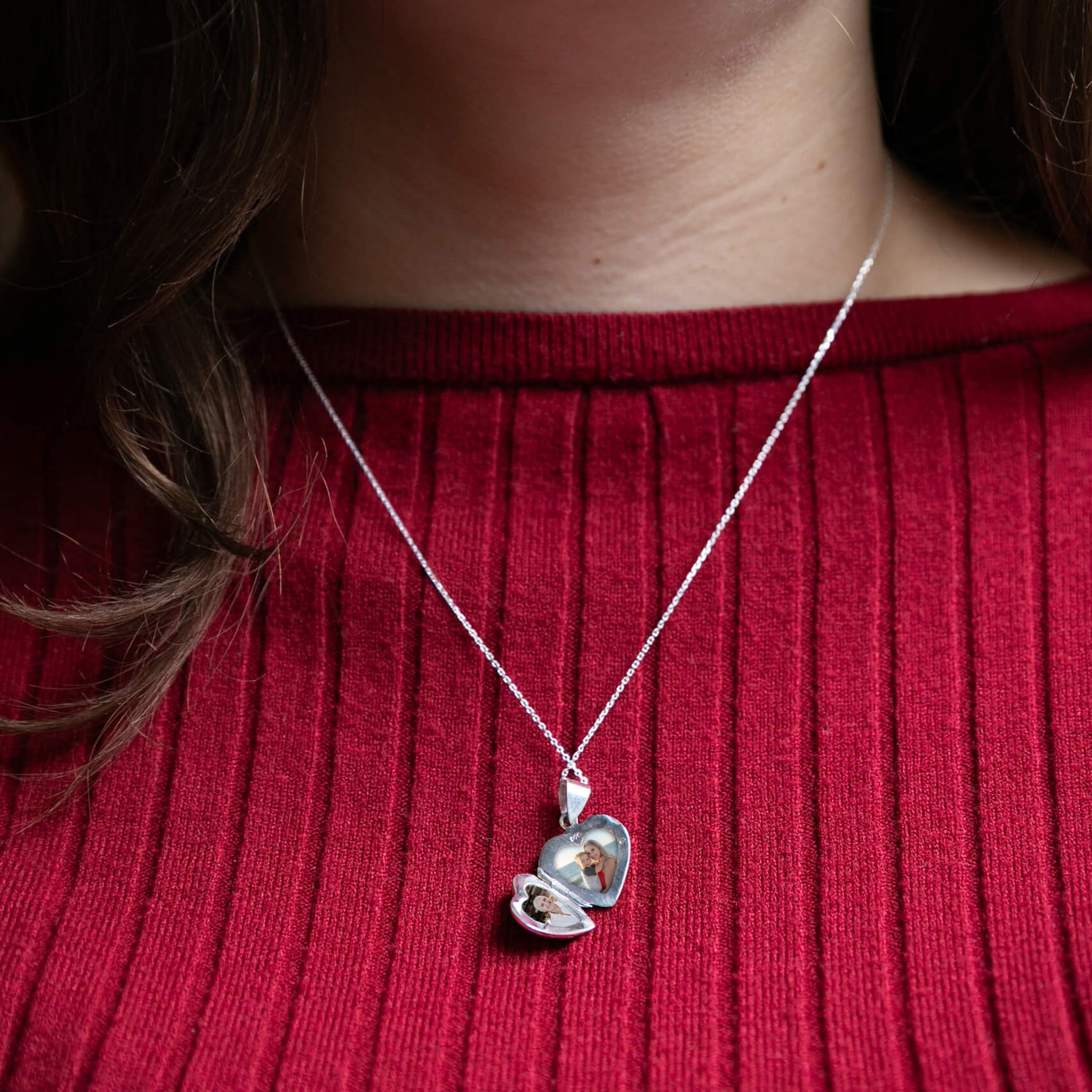 model in red wearing open photo locket with bow