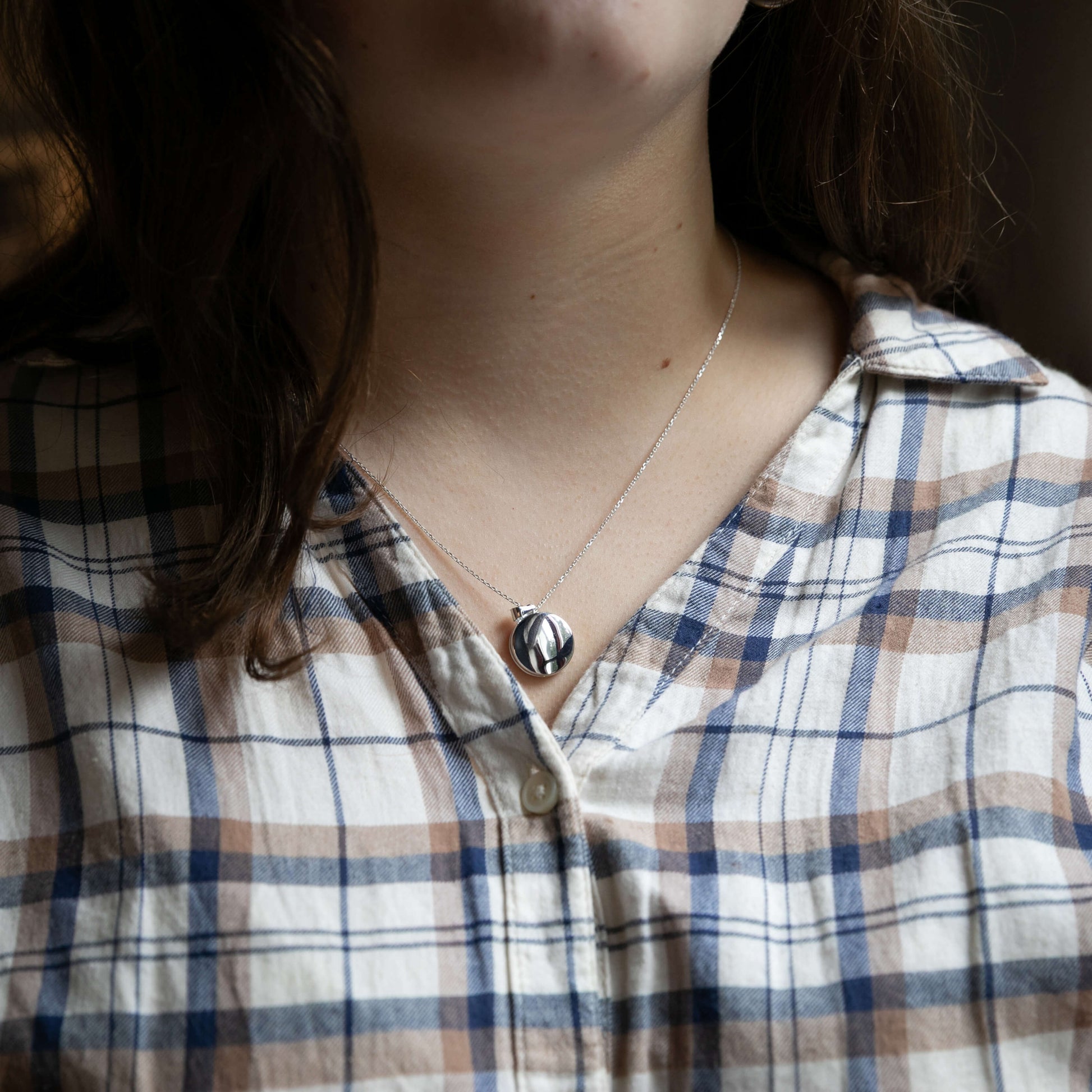 Model wearing round silver locket