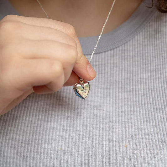 Model holding silver locket with chain 
