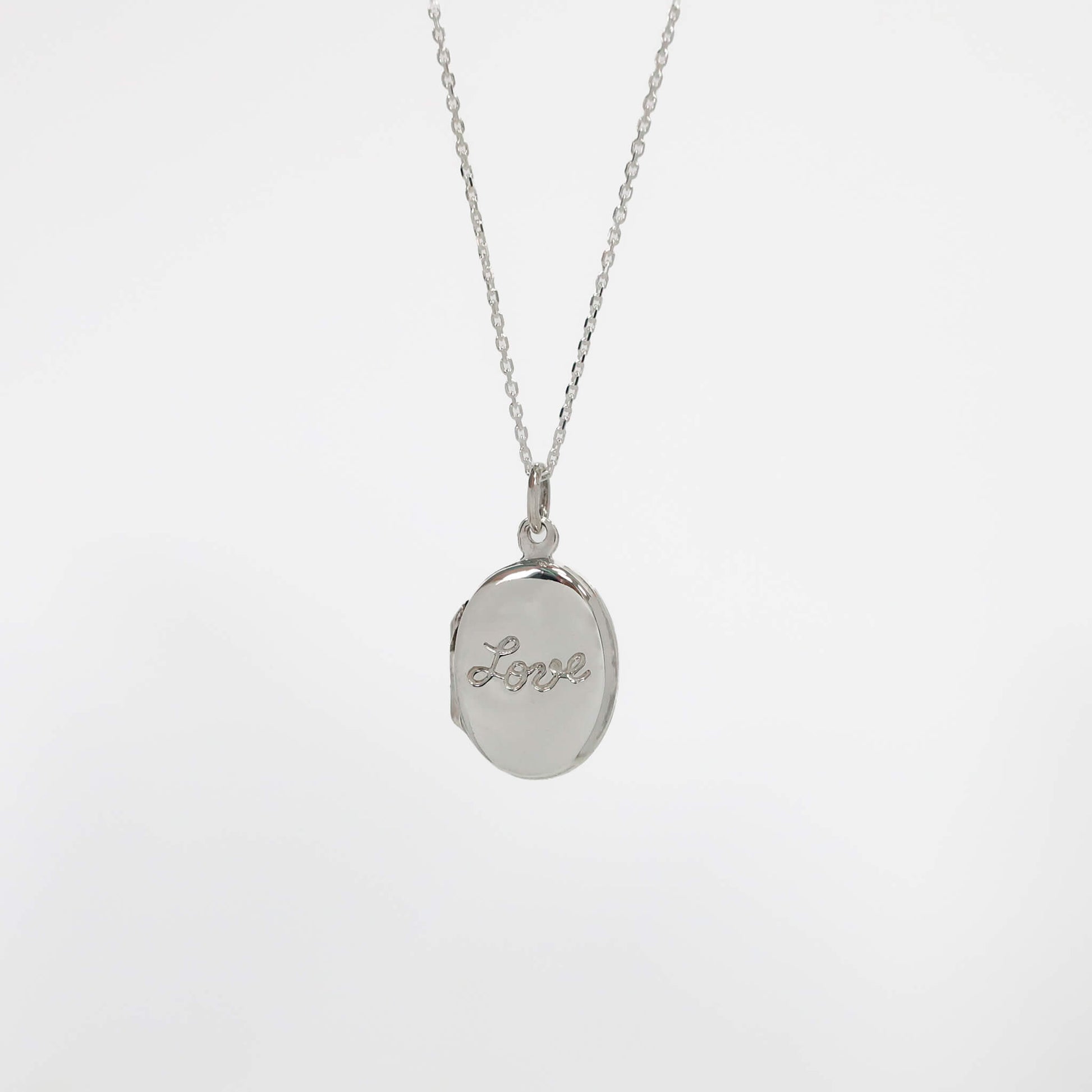 Silver photo locket necklace with a locket pendant engraved with 'love' on a light gray background