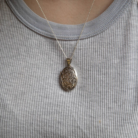 Model wearing large silver oval locket