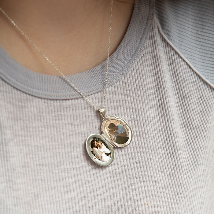 Model wearinglarge silver oval locket opened