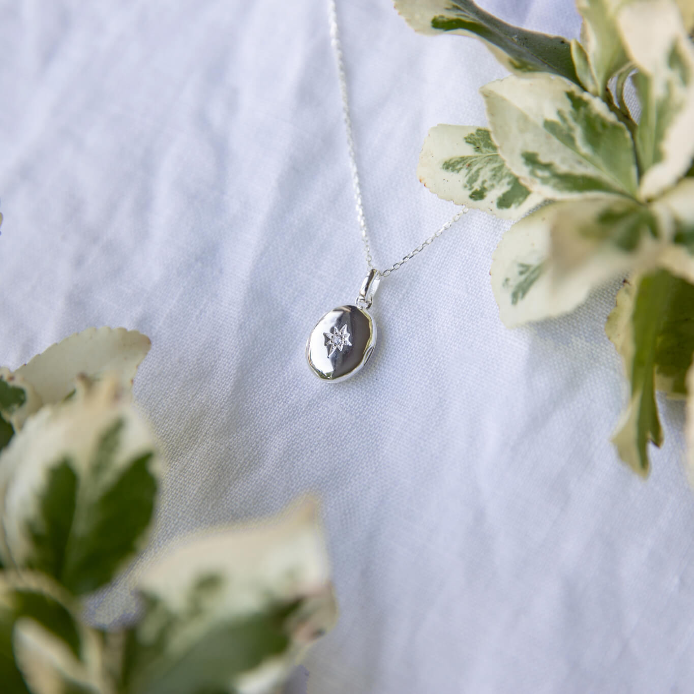 small oval locket on a white linen background