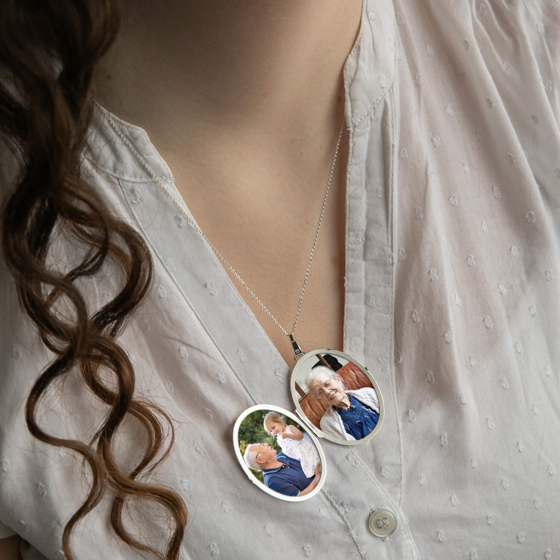 model with curly hair wearing extra large silver locket