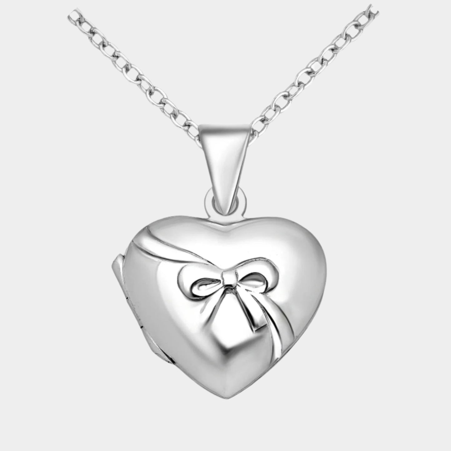 Silver heart shaped locket with bow embellishment. 