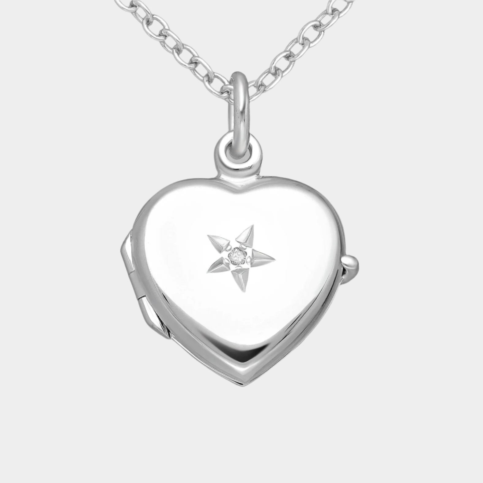 Heart shaped silver locket with star embellishment and white diamond
