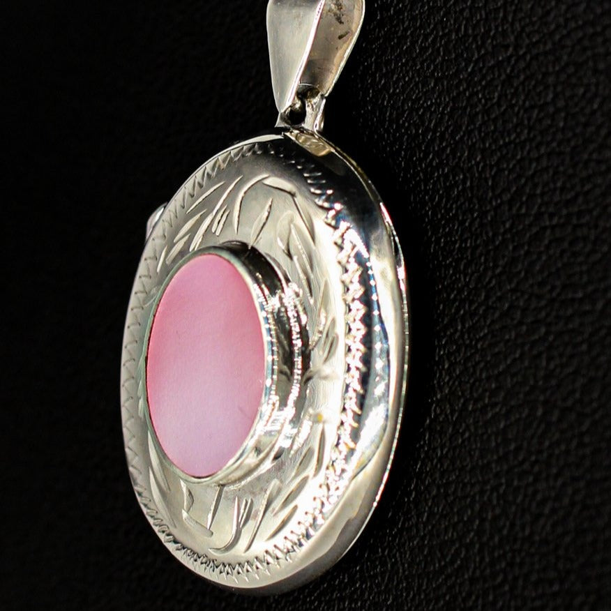 silver locket oval shaped with pink mother of pearl inset on a silver chain