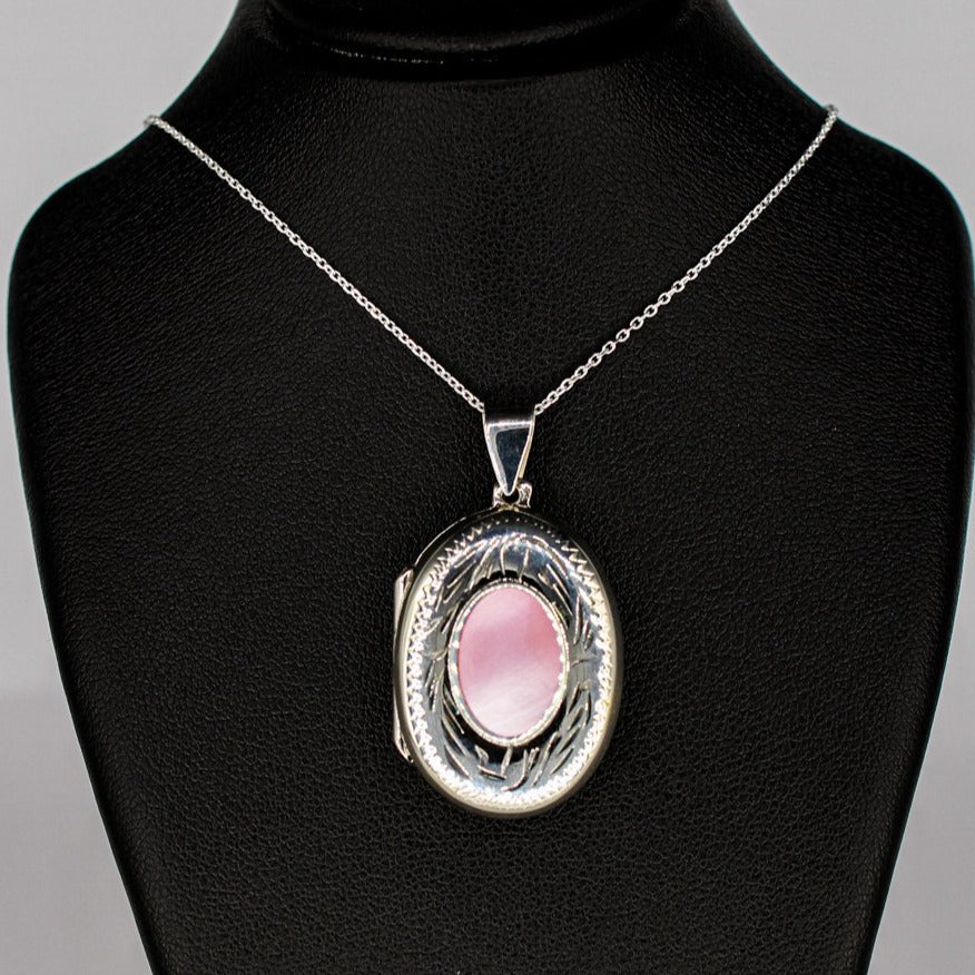 silver locket oval shaped with pink mother of pearl inset on a silver chain