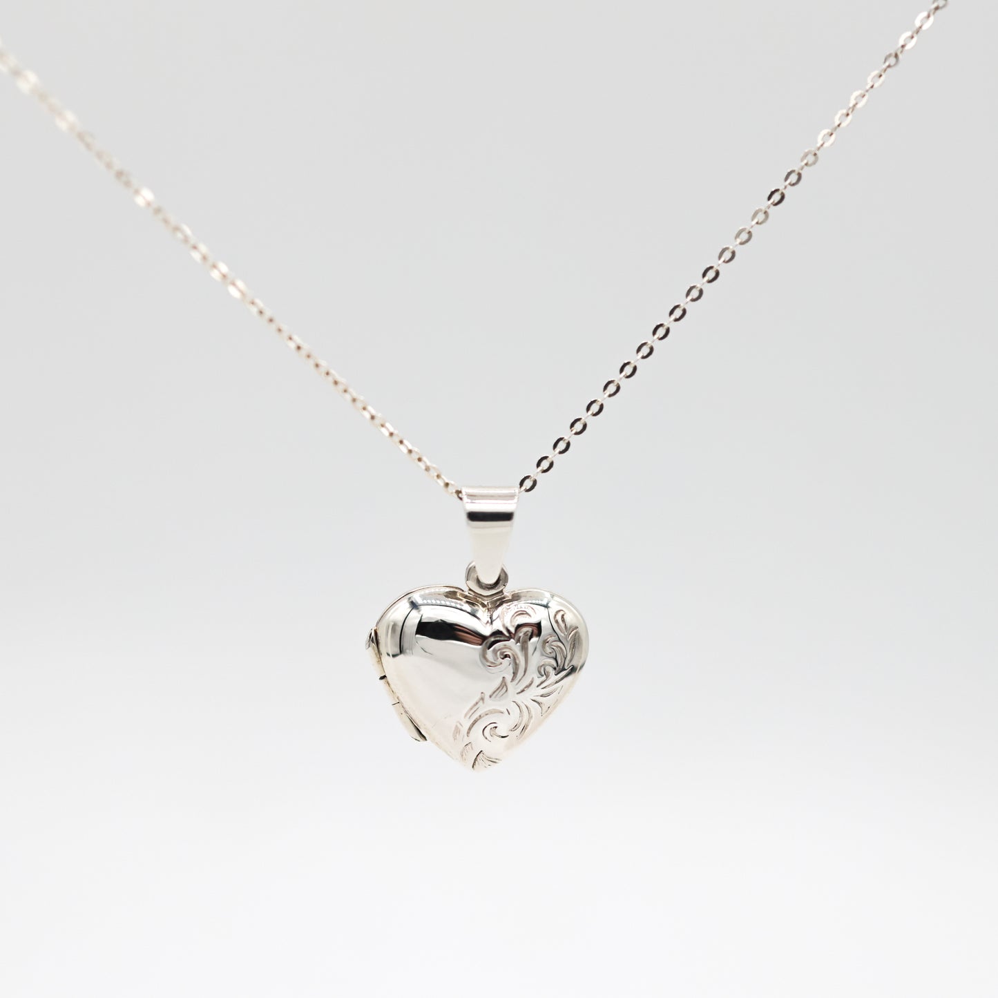 heart shaped photo locket with engraving on a white background