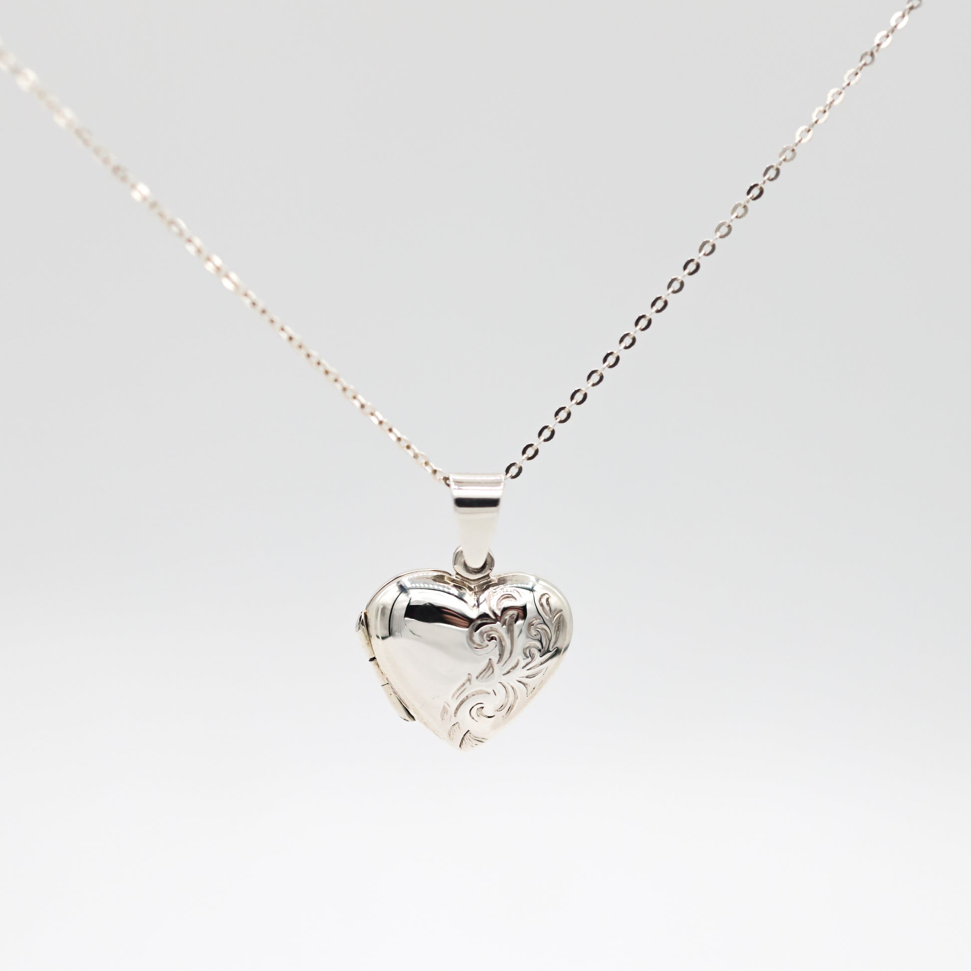 heart shaped photo locket with engraving on a white background