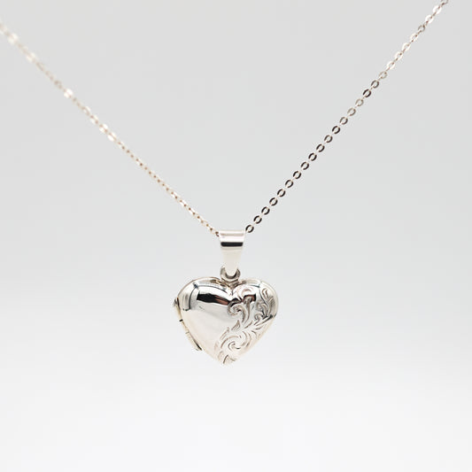 heart shaped photo locket with engraving on a white background