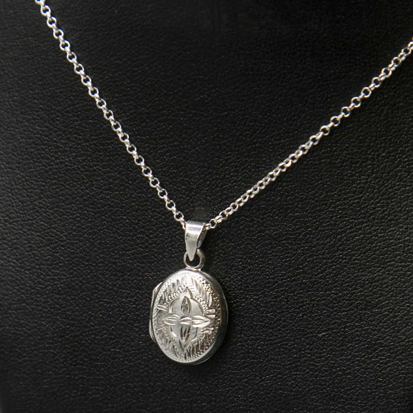 Embellished silver photo locket necklace with lily motif on Italian silver chain displayed on black bust.